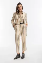 Pantalón de tiro alto con silueta tipo carrot, confeccionado en jacquard de algodón a rayas doradas, negras y crudas.