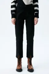 Pantalón chino negro elastizado con bolsillos ojal delanteros y aberturas en el ruedo.