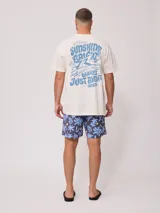 Remera de algodón color crema, corte oversize, con estampado frontal pequeño de la marca Rusty en azul.