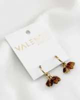 Aros colgantes dorados con dijes de piedras facetadas color marrón.