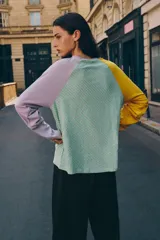 Camiseta de manga larga con diseño tricolor y patrón de rayas diagonales. Presenta cuerpo con rayas en verde y blanco, manga izquierda amarilla y manga derecha lila, con cuello redondo.