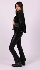 Camisa negra de cuero sintético con botones dorados.