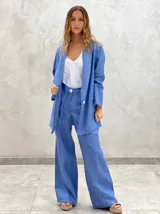 Blazer de lino celeste, de corte holgado y largo, con solapas y bolsillos frontales.