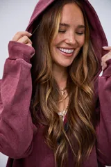 Cardigan con capucha color bordó, con efecto lavado y cierre frontal.