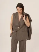 Chaleco marrón con rayas verticales rosas, de corte sastrero y sin mangas.