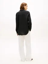 Camisa de lino puro color negro de Tommy Hilfiger, con cuello inglés, manga larga y cierre frontal de botones. Presenta un pequeño logo bordado en el pecho.