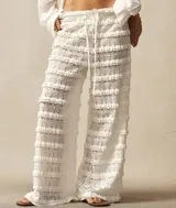 Pantalón de encaje blanco con volados horizontales y cintura con cordón ajustable.