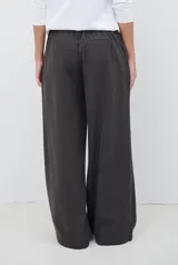 Pantalon de corte sastrero y pierna ancha, confeccionado en tela melange. Presenta cintura con trabillas, cierre frontal con botón y bolsillos laterales.