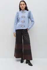 Pantalón de corte amplio y pierna ancha, confeccionado en gabardina de algodón con acabado engomado. Presenta un diseño de paneles horizontales en contraste de colores marrón y negro.