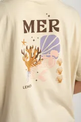 Remera color arena de algodón peinado, corte oversize y manga corta. Estampado pequeño de una concha en el pecho.