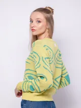 Sweater amarillo de tejido de punto con diseño de jacquard con ondas turquesas. Es de cuello redondo y manga larga.