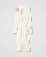 Maxi cárdigan tejido color crema con bordados florales y cinturón.