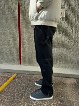 Pantalón de jean negro de corte recto, con bolsillos laterales y traseros, y presilla lateral para herramientas.