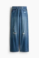 Jean de tiro alto con corte wide leg y diseño de cinco bolsillos. Presenta un acabado en denim azul con detalles de roturas desgastadas en la parte frontal.