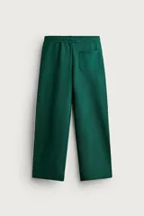 Pantalón jogger de corte relajado y pernera ancha, confeccionado en tejido de algodón con interior perchado. Cuenta con cintura elástica ajustable mediante cordón interior, bolsillos laterales y un bolsillo trasero de plastrón.