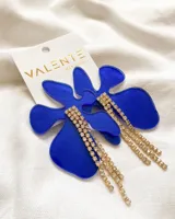 Aros colgantes con forma de flor en acrílico azul y detalle de strass dorados.