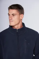 Campera de polar azul marino con cierre frontal completo, cuello alto y bolsillos laterales con cierre. Presenta un bolsillo vertical con cierre en el pecho y logo bordado.