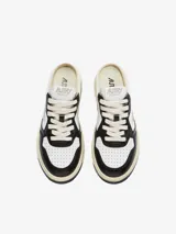 Zapatilla mule de cuero blanco y negro, con cordones y logo de la marca en el lateral.