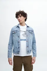 Campera de jean celeste de calce clásico, con cuello camisero, cierre frontal con botones metálicos, bolsillos con solapa abotonada en el pecho y bolsillos laterales.