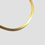 Collar tipo serpiente de acero dorado con diseño plano, flexible y brillante.
