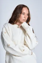 Sweater color crema de hilado frizado con cuello redondo y apliques de flores color beige en las mangas.