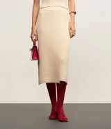 Pollera evasé midi de punto con cintura alta y elástico. Presenta un diseño con traspase delantero.