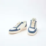 Zapatillas bajas de estilo deportivo, con capellada bicolor en blanco y azul. Presentan paneles superpuestos de material sintético, puntera perforada, cordones color crema y suela de goma color beige.