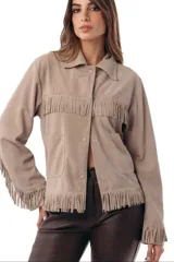 Campera de gamuza color crudo con flecos en el pecho, en el ruedo y en las mangas, cuello camisero, bolsillos frontales appliqués y cierre con broches a presión oculta.