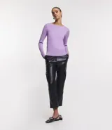 Suéter de punto color rosado, con cuello barco, mangas largas y puños con botones decorativos. El dobladillo también es acanalado.