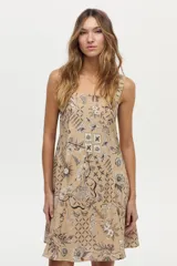 Vestido corto camel de lino y viscosa, con escote cuadrado, breteles anchos y diseño con godets. Presenta un estampado artesanal en tonos marrones y blancos.