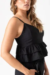 Top negro de tirantes finos con diseño de doble volado en la parte inferior y espalda con detalle de fruncido elástico.