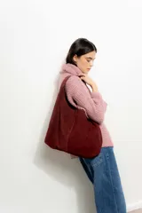 Bolso tote de gamuza color bordó con asa de hombro.