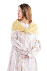 Chal pañuelo de formato triangular tejido a mano en lana merino y seda, con diseño de rayas horizontales en tonos beige y blanco.