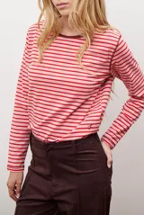 Remera de manga larga con diseño de rayas horizontales en azul y blanco, destacada por un cuello redondo en color bordó con costuras a la vista.