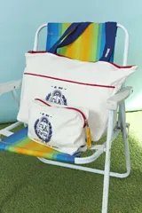 Estuche de algodón color natural con cierre rojo y bordado azul del escudo nacional en el frente.