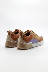 Zapatillas de cuero color tostado con detalles en marrón y lila.