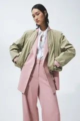 Blazer cruzado rosado con solapas de pico, hombreras y bolsillos delanteros con solapa. Cuenta con cierre de doble botonadura y forro interior.
