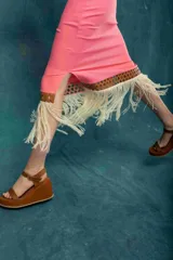 Pollera midi negra con detalle de cuero calado y flecos blancos en el ruedo.