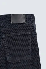 Pantalón de corte recto confeccionado en tejido de pana, con diseño de cinco bolsillos, cierre frontal con cremallera y botón.