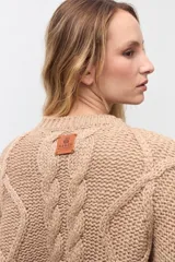 Sweater de punto color camel con cuello redondo y diseño de trenzas verticales en el frente y mangas. Presenta puños y ruedo acanalados.