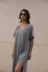 Vestido largo a rayas horizontales grises y negras, con cuello bote, mangas cortas y aberturas laterales. Incluye lazo en la cintura.