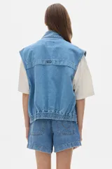 Chaleco de jean celeste con corte vintage y amplios bolsillos delanteros.