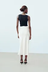 Camiseta blanca ajustada de poliamida con tirantes anchos y escote redondo.