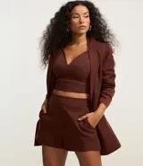 Short lila de tejido bengaline, con bolsillos delanteros y cremallera lateral.