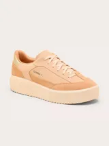 Championes Sorel modelo Ona Ave T-Toe, color beige con detalles en gamuza y cuero. Presenta suela de plataforma con diseño estriado y detalle metálico dorado en el talón.