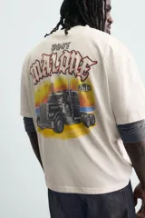Camiseta de corte relajado color crudo, con cuello redondo y manga corta. Presenta un estampado gráfico pequeño en el pecho y un diseño grande en la espalda relacionado con el artista Post Malone.