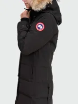 Campera negra acolchada con capucha y ribete de piel. Cierre frontal con botones a presión y bolsillos laterales.