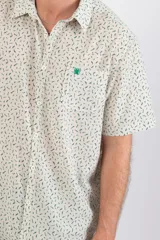 Camisa de manga corta con estampado de líneas verdes sobre fondo blanco, confeccionada en tela crepé.