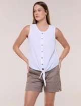 Blusa blanca sin mangas, confeccionada en algodón con sutiles rayas verticales en relieve. Presenta cuello redondo, cierre frontal con botones de madera y un nudo ajustable en el dobladillo delantero.