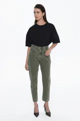 Pantalón de jean de tiro alto, color verde oliva desgastado, con calce relajado y piernas que se afinar hacia el tobillo.